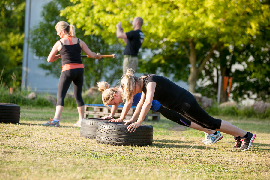 Bootcamp UK Guildford - Group outdoor fitness class, doing press-ups on the tyres