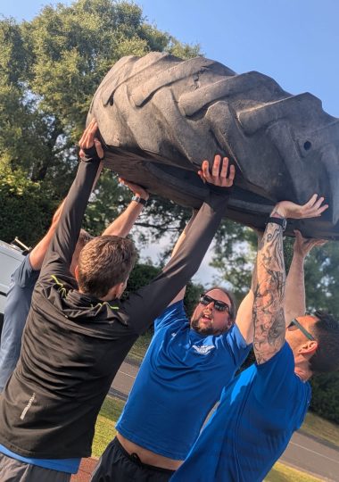 Group of people exercising outdoors in a park during a bootcamp class