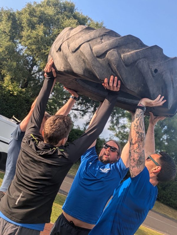 Group of people exercising outdoors in a park during a bootcamp class