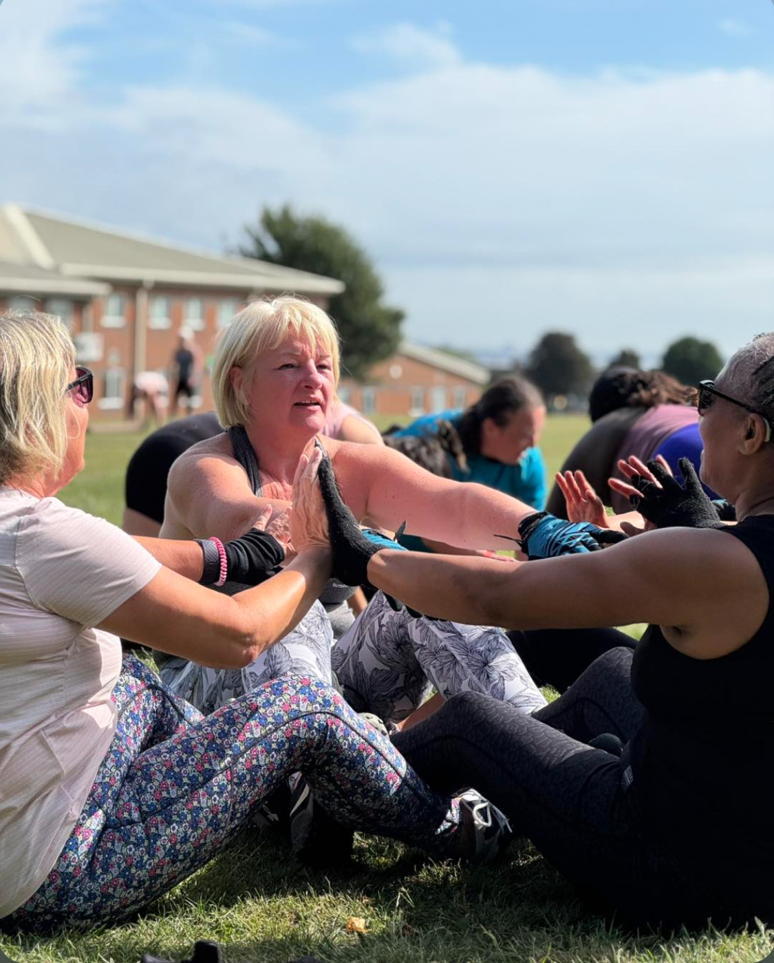 Mixed group of adults working out outdoors with a fitness coach.